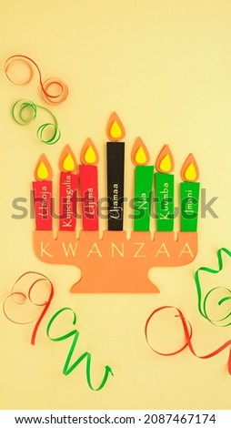 Candleholder made from paper with words in Swahili: Unity, Self-Determination, Collective Work and Responsibility, Cooperative Economics, Purpose, Creativity, Faith. Happy Kwanzaa background