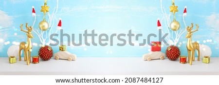 Image of christmas decorations and gold deer in front of pastel blue background