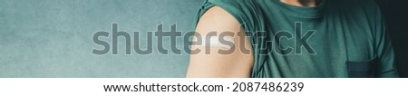 Male patient with plaster after Covid-19 vaccination and immunization procedure in hospital, panoramic image with selective focus Royalty-Free Stock Photo #2087486239