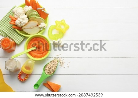 Composition with healthy baby food on light wooden background