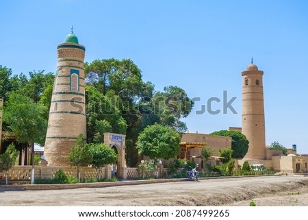 Historical buildings of Dishan-kala or "outer city" of Khiva, Uzbekistan. Left: Abdal Bobo mausoleum, right: Palvan-Kari madrasa. Translation of inscription: "Shrine Abdal Bobo" (in Uzbek and Persian)