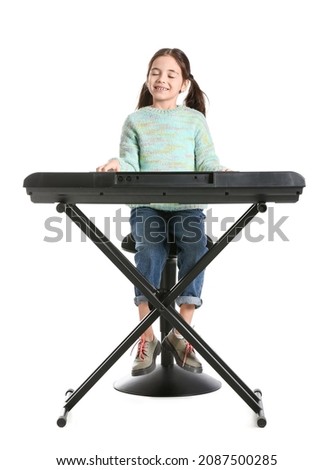 Little girl playing synthesizer on white background Royalty-Free Stock Photo #2087500285