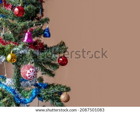 Merry Christmas and happy new year concept. Colorful ornaments hanging from a decorated tree. Xmas holiday background. . Selective focus. Noise effect. Space for text.