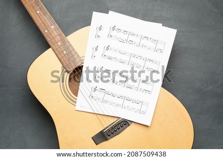 Acoustic guitar and music notes on dark background