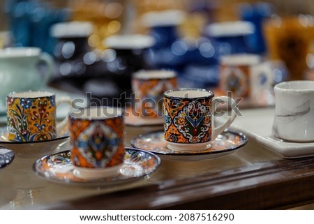 Colorful Turkish cups background. Ornamental cups with plates among different other mugs