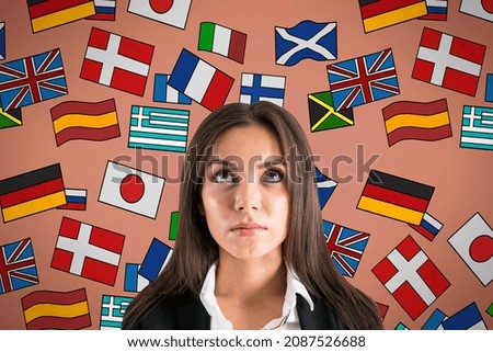 Portrait of attractive young european businesswoman with abstract colorful flag drawings. Travel, translation and language learning concept