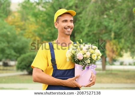 Delivery man with beautiful flowers outdoors