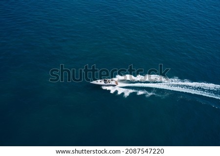 Boat performance U-turn on the water aerial view. Speedboat moving fast on dark blue water. Royalty-Free Stock Photo #2087547220