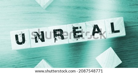 Wooden cubes with the word unreal on wooden background. Facts and figusres true and lies concept Royalty-Free Stock Photo #2087548771