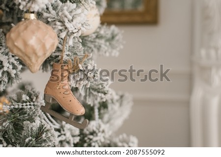 A toy in the form of a skate hangs on a silver Christmas tree with a copy space