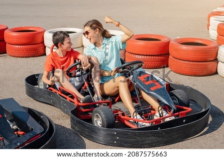 Mom and son have fun and go karting. Joint leisure for two and motorsport classes Royalty-Free Stock Photo #2087575663