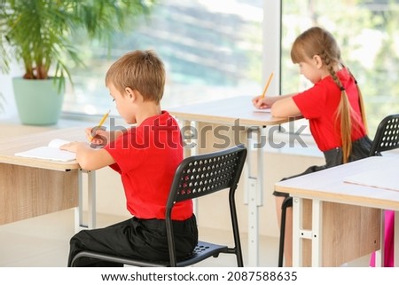Cute pupils during lesson in classroom Royalty-Free Stock Photo #2087588635
