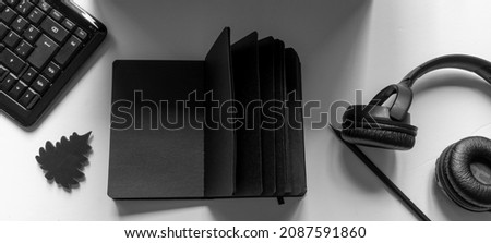Black objects on a white background. notebook, headphones, keyboard