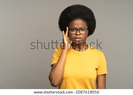 Shocked black female look surprised and astonished touching glasses with open mouth. Frustrated african woman hear unexpected bad news, horrified isolated over gray studio wall. Astonishment and shock