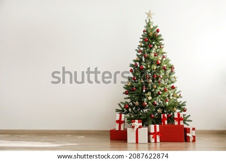 Traditional christmas pine tree with holiday decorations, copy space for text. Decorative lights glowing on fir. Close up, background, interior.