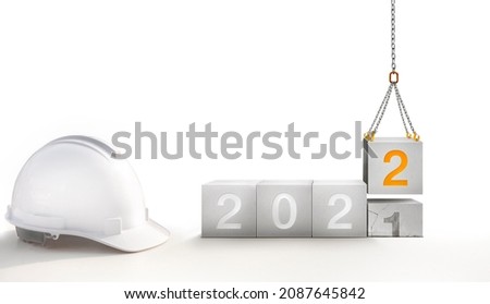 The year 2022 in concrete and raise numbers 2 new oranges by a construction crane on top the passed years 2021