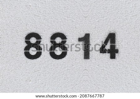 Black Number 8814 on the white wall. Spray paint. Number eight thousand eight hundred and fourteen.