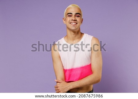 Young blond cool fun latin gay man 20s with make up wearing fashionable bright pink top look camera isolated on plain pastel purple background studio portrait. People lifestyle fashion lgbtq concept Royalty-Free Stock Photo #2087675986
