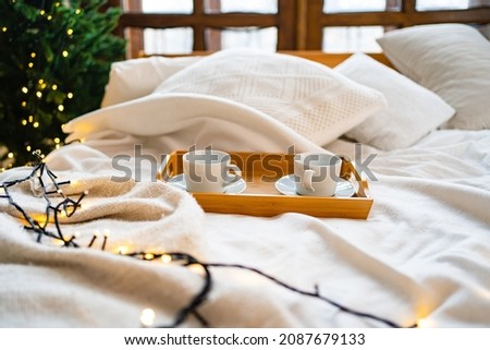 A wooden tray for eating in bed with two white tea cups. accessories and items for the kitchen and bedroom. shop of dishes and furniture. romantic breakfast. Royalty-Free Stock Photo #2087679133