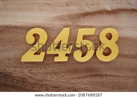 Golden Arabic numerals 2458 on a dark brown to white wood grain background.