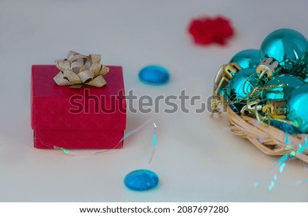 The gift box is a decorative box in which to place a gift. On a gray background with shiny green Christmas balls.