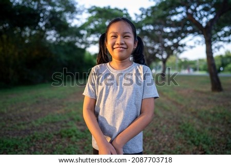 Portrait of young girl smile, green garden background.