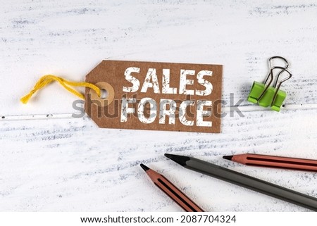 Sales Force. Cardboard prices sign on a white wooden table.