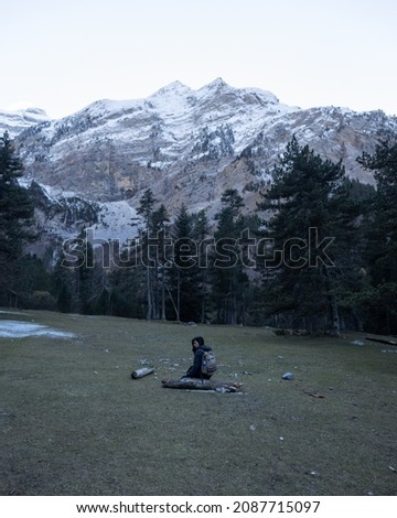 Woman taking a rest pines background and a snowy mountain - Cirque de Gavarnie - Pyrenees - France