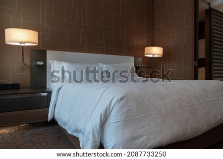 Elegant and comfortable home and hotel bedroom interior.There's a nice rug and a bedside lamp.