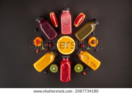Flat-lay of colorful smoothies in bottles with fresh tropical fruit and superfoods on concrete background Royalty-Free Stock Photo #2087734180