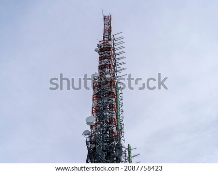 Group of antennas, satellite dishes for telecommunications, television broadcast, cellphone, radio and satellite on Linzone mountain peak. Electromagnetic and environmental pollution. Italian Alps