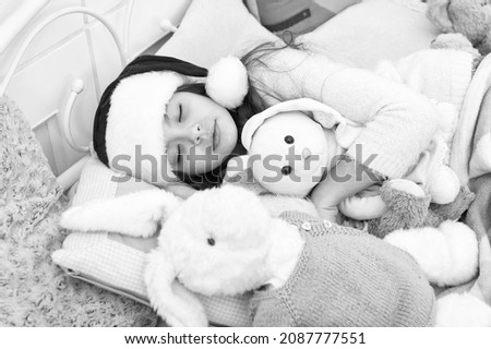 Magical morning. Christmas eve concept. Cozy room. Small child relaxing in bedroom. Kid lay in bed relaxing. Sweet home. Girl little kid relaxing on bed light interior with christmas decorations