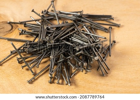 construction metal nails small on wooden background