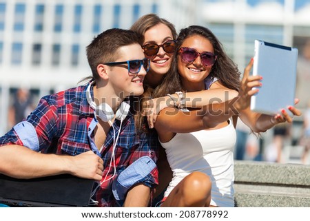 friends with laptop sitting on a steps outdoors
