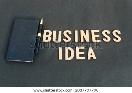 business idea background concept. Wooden cubes words Business ideas isolated on black  background. Design for ideal poster, web, cover, ad, social media, promotion. 