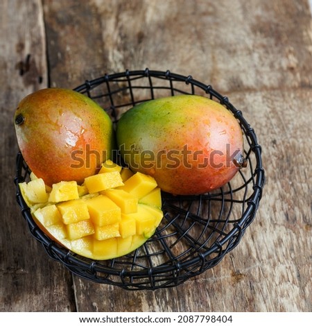 Tropical mango fruit is green, on a wooden table. Healthy food