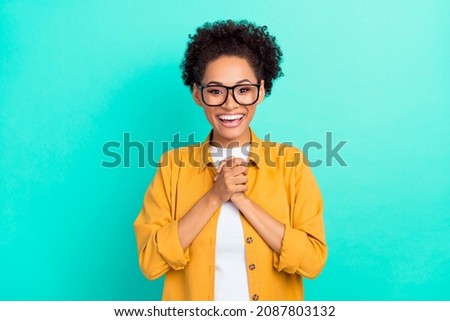 Photo of young lovely afro girl excited good mood hands together rejoice isolated over turquoise color background