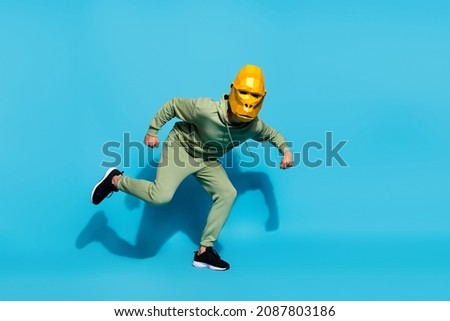 Photo of funky hurry positive energetic weird guy prepare run wear gorilla mask sportswear isolated blue color background