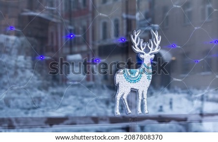 The showcase is decorated with a Christmas sticker. Deer on glass. Christmas