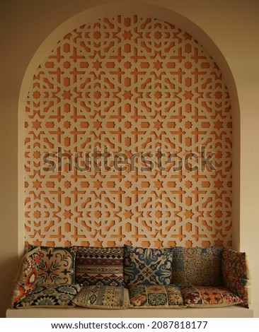 Morocco interior style. Colorful asian pillows on the couch near wall with pattern. Middle east arch interior. Arabic style. Morocco design room Royalty-Free Stock Photo #2087818177