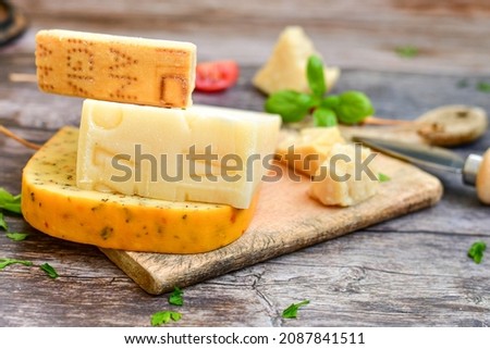  Set of different kinds ot delicious   Italian hard  cheeses,  cheese knives  and walnuts on wooden cheese board.Parmesan. Top view.