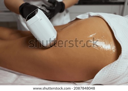 Young African woman getting laser hair removal on her thighs.