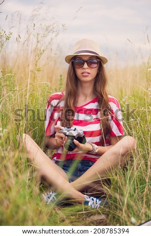 Girl with vintage camera in a field