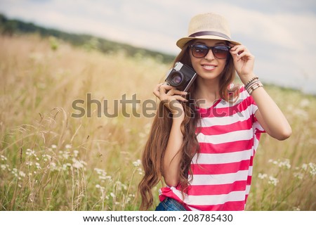 Girl with vintage camera in a field