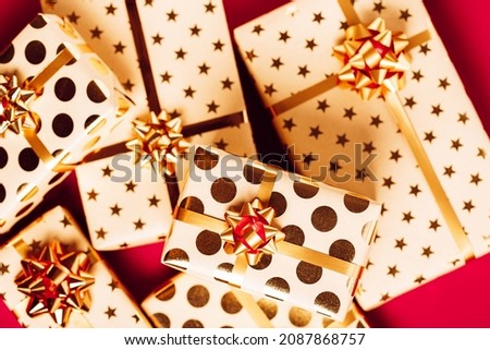 Gift boxes with golden bows on red background.