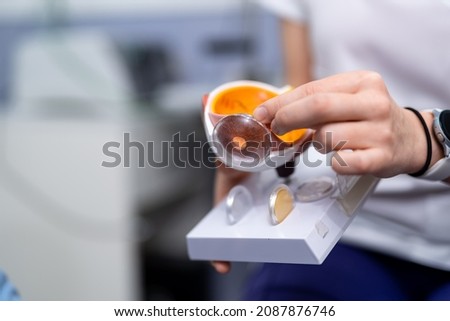 Ophthalmologist or surgeon holds an eye, eyeball prosthesis in hands . Concept photo for ocular prosthesis, diagnosis treatment of ophthalmic diseases, surgical operations on eyes. Closeup Royalty-Free Stock Photo #2087876746