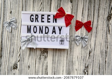 Lightbox with Green Monday text, crafting gift box, Christmas festive decorations. Concept of online shopping. View from above.