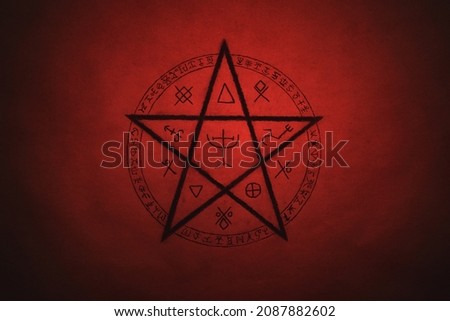Pentagram symbol painted on paper with black paint. Occult and esoteric symbols. Spell or black magic ritual. Red color. Royalty-Free Stock Photo #2087882602