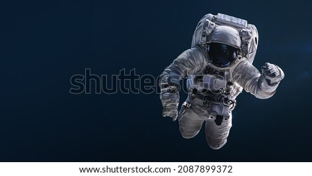 Astronaut floating and isolated on dark background. Spaceman sci-fi space wallpaper. Elements of this image furnished by NASA 