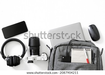 Gray backpack and many modern electronic gadgets on a white background. The concept of gadgets for travel, trip and study. The concept of a backpack for a photographer or a traveler. Duotone. Close-up Royalty-Free Stock Photo #2087904211